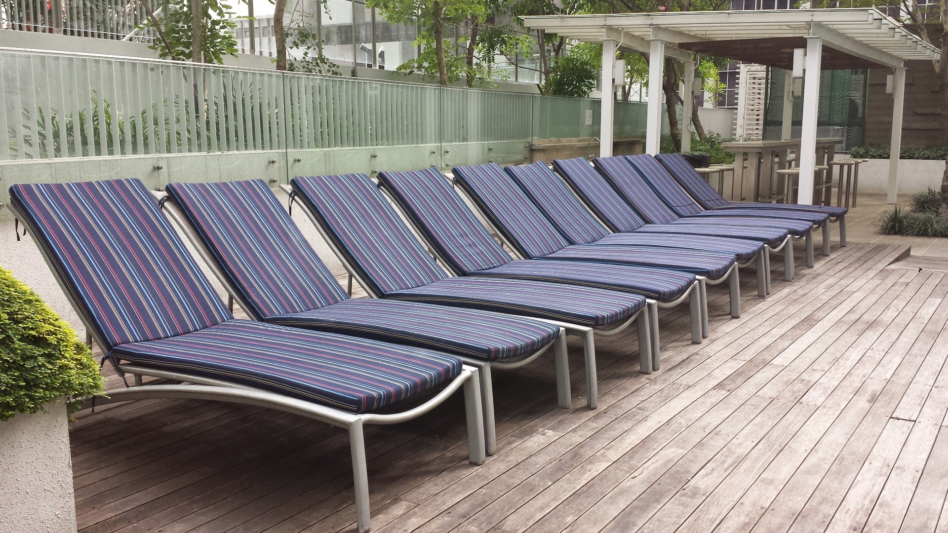 Before: weathered teak sling lounger with sagging, faded outdoor mesh fabric beside a Singapore condominium pool