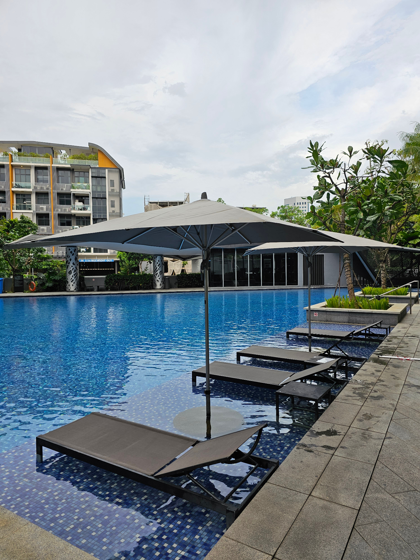 Before: poolside daybed with flat, mildew-stained outdoor cushions at a Singapore residence